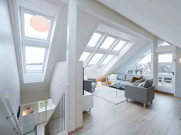 La pose de fenêtres de toit velux permet d'apporter de la lumière dans espace de vie. Ici sont combinées plusieurs velux pour éclairer des combles récemment convertis en salon supplémentaire.